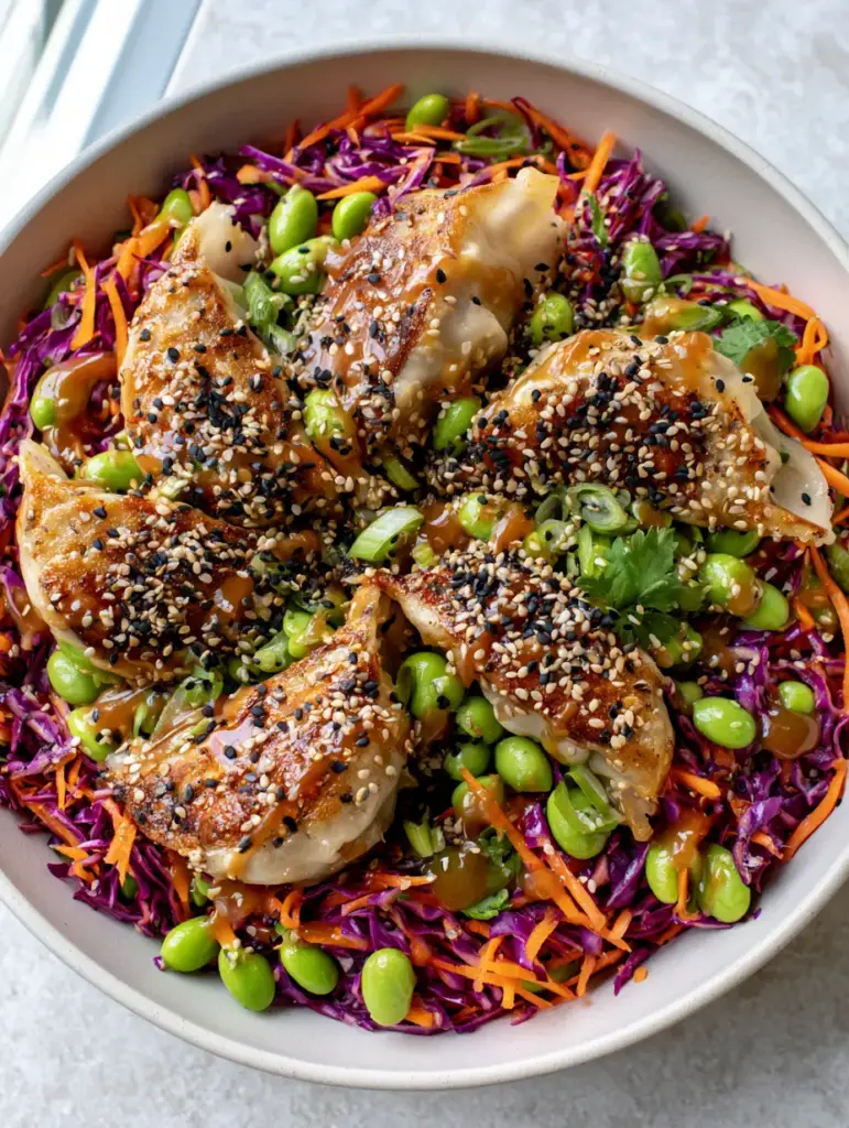 Potsticker Salad with Crispy Pork Dumplings and Sesame Ginger Dressing 2 Aesthetic food photography of potsticker salad showing the contrast between purple cabbage and bright orange carrots on a stone background.