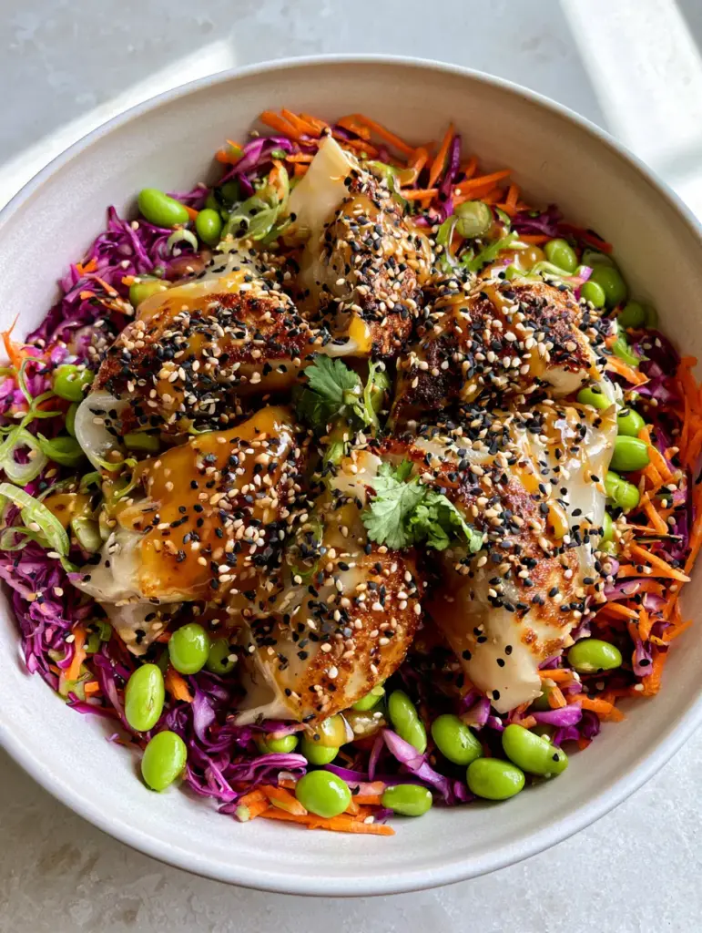 Potsticker Salad with Crispy Pork Dumplings and Sesame Ginger Dressing 1 Potsticker salad drizzled with glossy amber sesame ginger dressing and garnished with black and white sesame seeds.